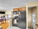 Compact kitchen with black appliances, wooden cabinets, and a small dining area at 7751 Niagara St, Commerce City, CO 80022