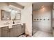 This bathroom features dual sinks, vanity storage, a shower, and stone and tile accents at 8965 Jellison Ct, Broomfield, CO 80021