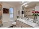 Charming bathroom with a decorative mirror, marble countertop and shower-tub combo at 8965 Jellison Ct, Broomfield, CO 80021