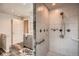 The shower with tile surround is complemented by a gray vanity with stone countertop in this bathroom at 8965 Jellison Ct, Broomfield, CO 80021