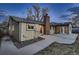 Rear view of the exterior with a brick chimney and concrete patio, offering an outdoor living space at 8965 Jellison Ct, Broomfield, CO 80021