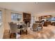 The brick fireplace anchors a cozy living room and dining area with hardwood floors and bright natural light at 8965 Jellison Ct, Broomfield, CO 80021