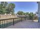 Backyard view showcasing a wood deck and a tall wood fence, surrounded by trees at 1272 Bluebird St, Brighton, CO 80601