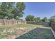 Spacious backyard featuring a tall wood fence and scattered trees around the perimeter at 1272 Bluebird St, Brighton, CO 80601