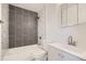 Modern bathroom with gray tile accent wall, and combined shower and tub at 1272 Bluebird St, Brighton, CO 80601