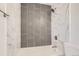 Modern bathroom features a tiled shower-tub with grey accent tiles and brushed nickel fixtures at 1272 Bluebird St, Brighton, CO 80601