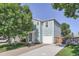 Charming two-story home featuring blue siding, a one car garage and mature trees at 1272 Bluebird St, Brighton, CO 80601