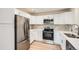 Modern kitchen featuring stainless steel appliances, white cabinets, and a stylish backsplash at 1272 Bluebird St, Brighton, CO 80601
