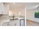 Open kitchen and living area with stainless steel appliances and a marble backsplash at 1272 Bluebird St, Brighton, CO 80601