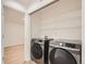 Laundry room with appliances, closet, wire shelves, and laminate floors at 1272 Bluebird St, Brighton, CO 80601