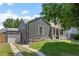 Home exterior featuring a detached garage, grey siding, and a well-maintained lawn at 1738 S Franklin St, Denver, CO 80210