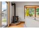 Cozy living room with a traditional wood stove, bay window and wood floors at 1738 S Franklin St, Denver, CO 80210