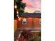 Charming brick exterior with string lights creates a warm and inviting ambiance in the beautifully landscaped backyard at 4150 Raritan St, Denver, CO 80211