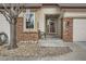 Inviting front entrance with brick pillars, a security door, a decorative wreath, and stone landscaping at 6187 Terry Way, Arvada, CO 80403