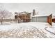 Backyard view showcasing a deck with stairs and a gray building exterior with snowy surroundings at 2152 Grant St, Longmont, CO 80501