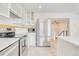 Modern kitchen with stainless steel appliances, white cabinets, and a view into the living area at 2152 Grant St, Longmont, CO 80501