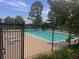 Community pool surrounded by a black iron fence and mature trees at 10310 E Jewell Ave # 55, Aurora, CO 80247