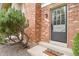 A close-up of the front door to a brick townhouse with well-maintained landscaping at 10310 E Jewell Ave # 55, Aurora, CO 80247