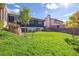 Backyard features a lush lawn, mature tree, and view of the home's exterior at 2427 S Eldridge Ct, Lakewood, CO 80228