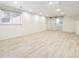 Finished basement with wood floors, sliding barn door, and natural light at 2427 S Eldridge Ct, Lakewood, CO 80228