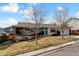 Well-maintained home showcasing a unique dark and light exterior with a vibrant blue front door at 2427 S Eldridge Ct, Lakewood, CO 80228