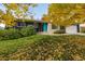 Charming single-Gathering home featuring a striking dark exterior, a bright blue door, and lovely autumn foliage at 2427 S Eldridge Ct, Lakewood, CO 80228