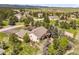 Aerial view showcases a home surrounded by lush greenery and scenic mountain views in the distance at 1590 Longview Cir, Monument, CO 80132
