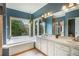 A spa like bathroom featuring a garden tub, vanity with double sinks, and large window at 1590 Longview Cir, Monument, CO 80132