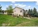 Backyard exterior view of a two-story home showcasing its well-maintained lawn and lush landscaping at 1590 Longview Cir, Monument, CO 80132