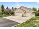 Exterior view of a home featuring a three-car garage and a manicured front yard with blooming trees at 1590 Longview Cir, Monument, CO 80132