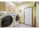 Convenient laundry room includes full-sized washer and dryer, storage cabinets, and a laundry sink at 1590 Longview Cir, Monument, CO 80132