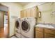 A laundry room featuring large capacity washer and dryer and built-in cabinetry at 1590 Longview Cir, Monument, CO 80132