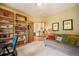 Bright office with built-in bookshelves, comfortable sofa, and glass doors leading to another room at 1590 Longview Cir, Monument, CO 80132