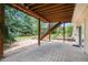 Covered patio with stone flooring and views of the landscaped backyard, providing a serene outdoor space at 1590 Longview Cir, Monument, CO 80132