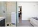 Modern bathroom features a glass shower stall with a tiled interior and a peek at the adjacent bedroom at 1922 E 18Th Ave, Denver, CO 80206