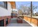 Side exterior view of a renovated home with a brick foundation and wood privacy fence at 1922 E 18Th Ave, Denver, CO 80206