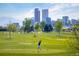 Scenic view of golfer teeing off, set against the backdrop of the Denver skyline and lush green fairways at 1922 E 18Th Ave, Denver, CO 80206