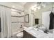 Clean bathroom with a shower-tub combo, decorative tile accents, marble vanity, and modern lighting at 3126 Perry St, Denver, CO 80212