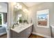 Bathroom features double sink vanity, framed mirror, modern lighting and outside views at 3126 Perry St, Denver, CO 80212