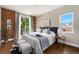 Serene main bedroom featuring a brick accent wall, hardwood floors, ample natural light, and a balcony view at 3126 Perry St, Denver, CO 80212