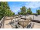 Relax on this home's rooftop deck with stylish chairs and a sleek fire pit under the beautiful blue sky at 3126 Perry St, Denver, CO 80212