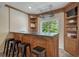 Basement wet bar with wood cabinetry, countertop, and bar seating at 580 Eagle Nest Ct, Golden, CO 80401