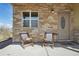 Inviting porch with stone facade, cozy seating, and a well-lit entryway at 6760 Meade Cir # C, Westminster, CO 80030
