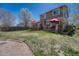 Well-manicured backyard with a lush lawn, a wooden deck, and a red umbrella for outdoor relaxation at 18655 E Garden Pl, Aurora, CO 80015