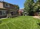 Large lawn with mature trees and a deck at 18655 E Garden Pl, Aurora, CO 80015