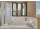 Relaxing bathroom featuring a large soaking tub and shower stall with clear glass door at 18655 E Garden Pl, Aurora, CO 80015