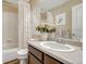 Well-lit bathroom with a neutral palette featuring a bathtub, shower, and functional vanity at 18655 E Garden Pl, Aurora, CO 80015