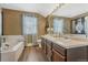 Bright bathroom with double sinks, wood-look floors, and natural light from a large window at 18655 E Garden Pl, Aurora, CO 80015