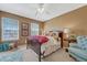 Sunny bedroom with two windows, a comfortable armchair, and warm neutral tones at 18655 E Garden Pl, Aurora, CO 80015