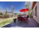 Inviting outdoor deck with a red umbrella, dining table, and views of the lush green lawn at 18655 E Garden Pl, Aurora, CO 80015